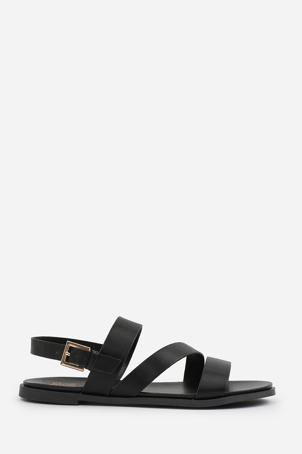 NESSA FLAT SANDALS WITH CROSS OVER STRAP AND BUCKLE CLOSURE IN BLACK FAUX LEATHER