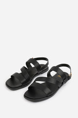 NESSA WIDE FIT FLAT SANDALS WITH CROSS OVER STRAP AND BUCKLE CLOSURE IN BLACK FAUX LEATHER