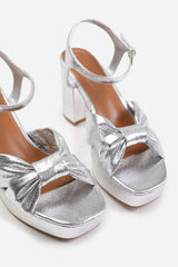 TALIA WIDE FIT MID BLOCK HEEL WITH PLAFTORM AND BOW DETAILING IN SILVER FAUX LEATHER