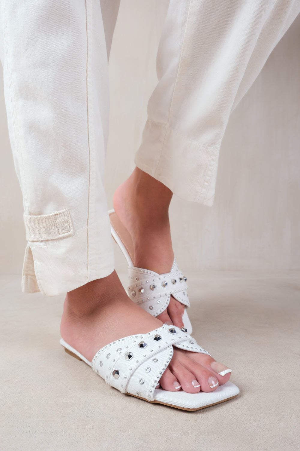 SATURN DOUBLE CROSS OVER STRAP FLAT SANDALS WITH STUD DETAILS IN WHITE FAUX LEATHER