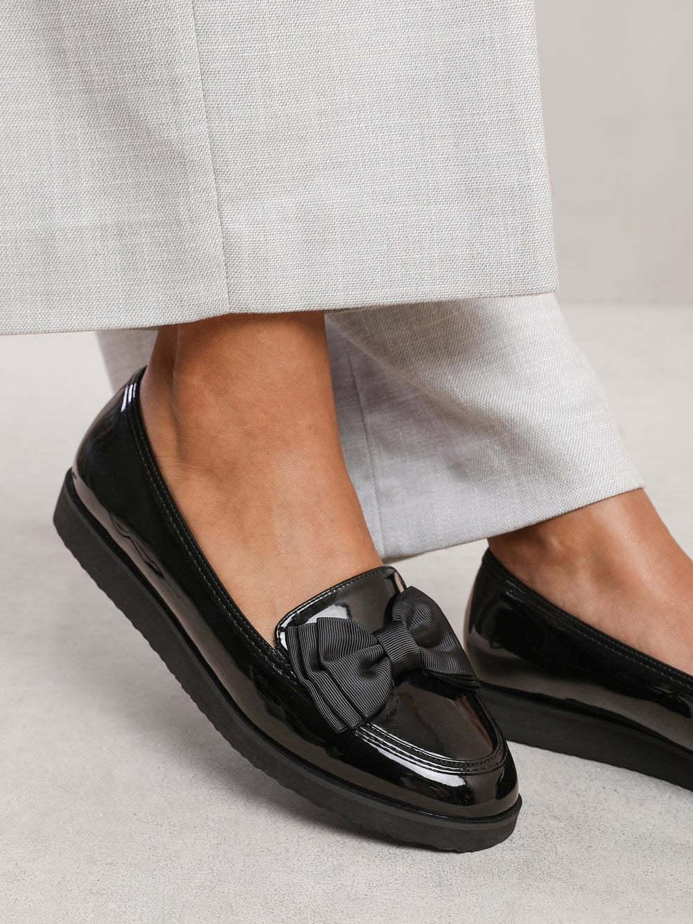 ALPHA SLIP ON LOAFER SLIDER WITH BOW DETAIL IN BLACK PATENT FAUX LEATHER