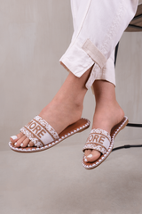 NOTE STRAP FLAT SANDALS WITH BEADED TEXT DETAIL IN WHITE FAUX LEATHER