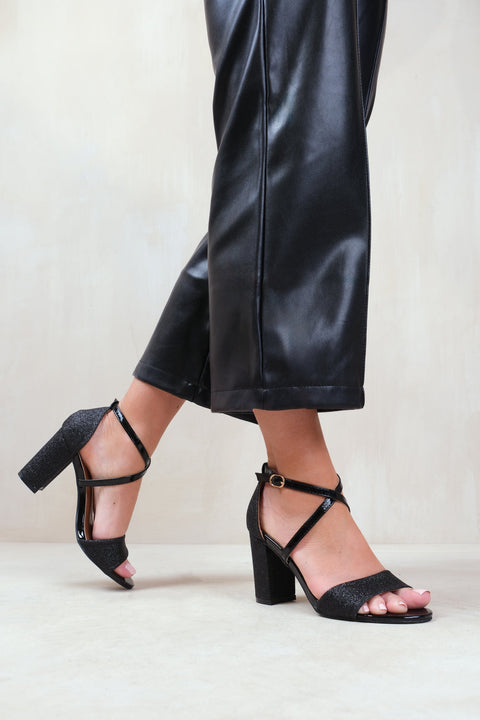 RUTH WIDE FIT HIGH BLOCK HEEL SANDALS WITH CROSS OVER ANKLE STRAP IN BLACK GLITTER