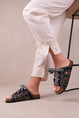 PARADOX STRAPPY FLAT SANDALS WITH PRINTED RIBBON DETAILING IN BLACK FAUX LEATHER
