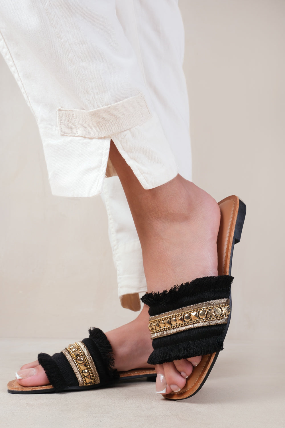ASTROID FLAT SANDALS WITH FRINGE TRIM AND STUD DETAILS IN BLACK