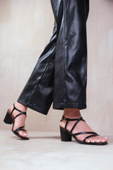 SIDRA MID HIGH BLOCK HEEL SANDALS WITH CROSS OVER STRAP IN BLACK FAUX LEATHER