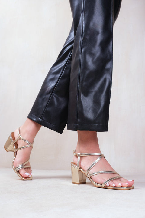 SIDRA WIDE FIT MID HIGH BLOCK HEEL SANDALS WITH CROSS OVER STRAP IN GOLD METALLIC FAUX LEATHER